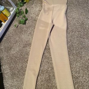 Tan one arm, one piece romper.